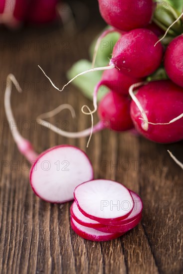 Chopped Radishes (close-up shot) on an old wooden table (selective focus)