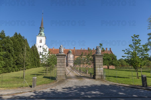 Brahetrolleborg church and castle, castle entrance, lions with coat of arms, trees, lawn, Faborg,