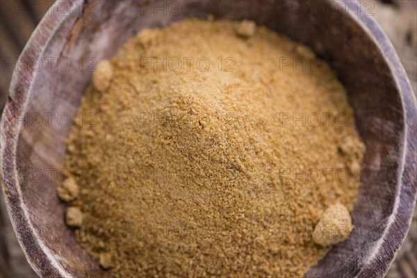 Portion of golden Coconut Sugar (selective focus) on vintage wooden background