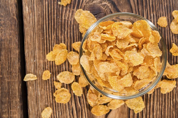 Portion of golden Cornflakes on wooden background (close-up shot)