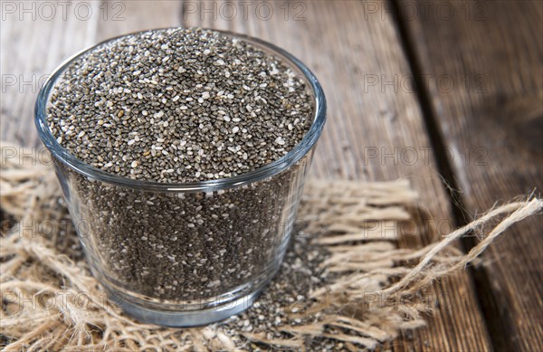 Chia Seeds in a small bowl (on dark wooden background)