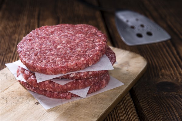 A raw Burger (minced Beef) on dark wooden background