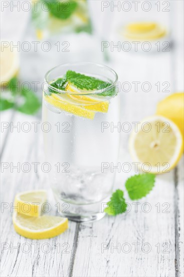 Homemade Lemonade on an wooden table (selective focus) as detailed close-up shot