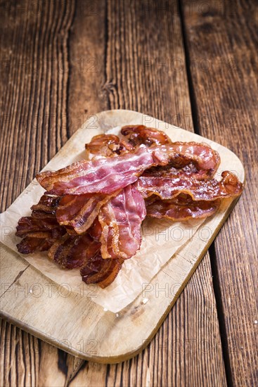 Portion of fried Bacon (selective focus) on wooden background