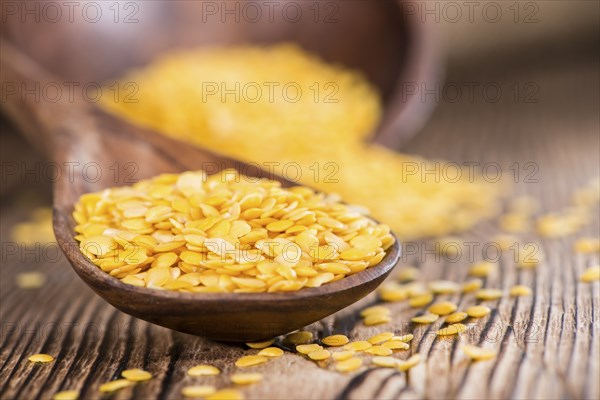 Portion of Yellow Lentils on vintage wooden background