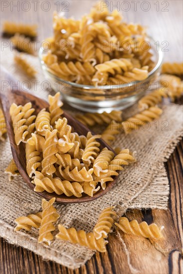 Portion of uncooked Wholemeal Fussili on wooden background