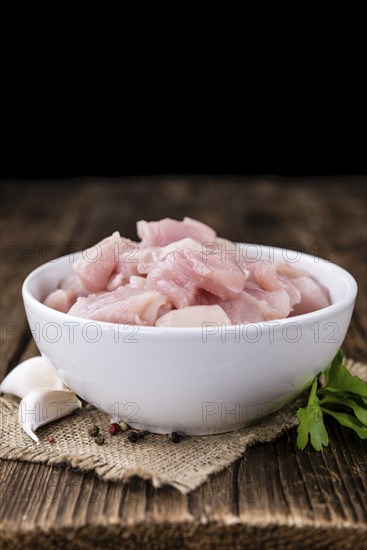 Portion of chopped Chicken Fillet (close-up shot) on wooden background