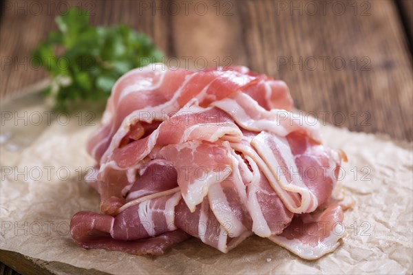 Raw Bacon slices (detailed close-up shot) on vintage wooden background