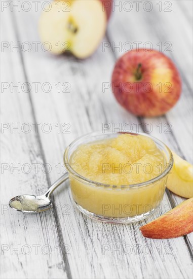Homemade Applesauce (selective focus, close-up shot) on vintage background with some fresh fruits
