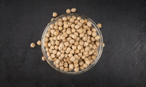 Portion of dried Chickpeas on a rustic slate slab, selective focus, close-up shot