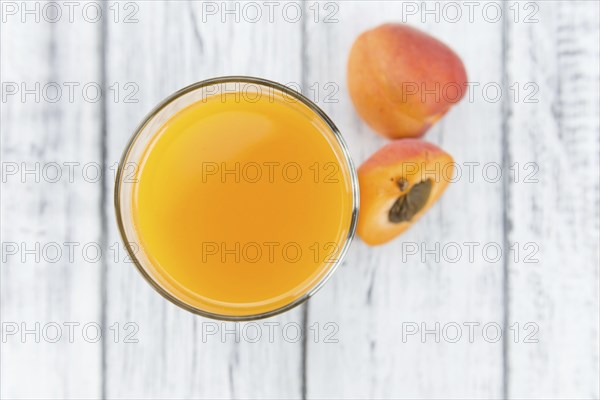 Homemade Apricot Juice on an wooden table (selective focus) as detailed close-up shot