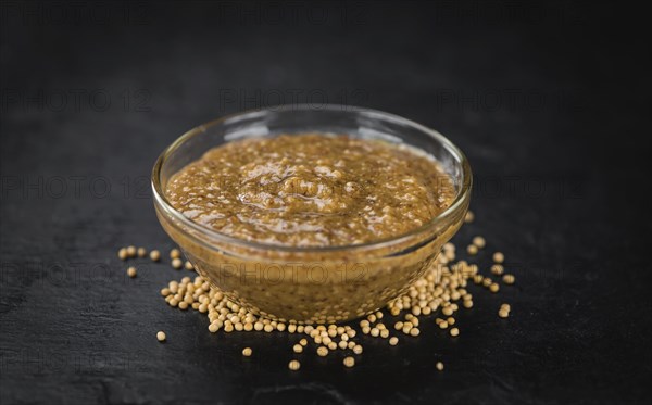 Fresh made German Cuisine (sweet Mustard) on a vintage background (close-up shot)