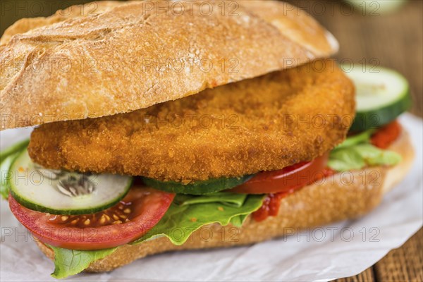 Old wooden table with a Chicken Schnitzel (selective focus, close-up shot)