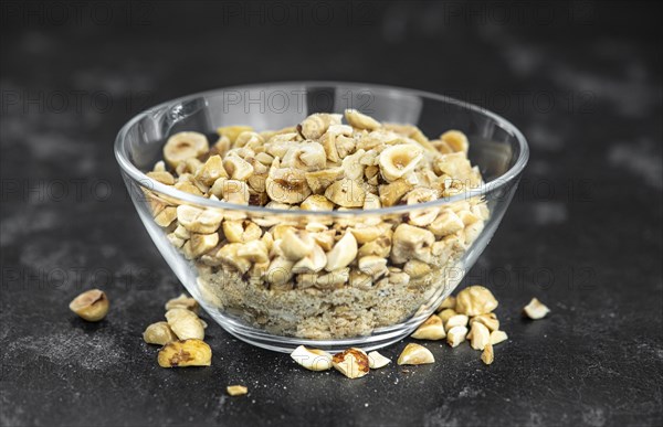 Freshly chopped Hazelnuts as detailed close up shot (selective focus)