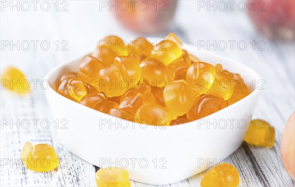 Gummy Peaches (detailed close-up shot) on an old wooden table