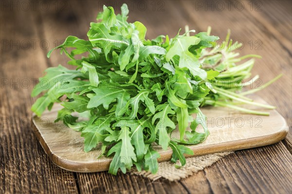 Fresh Arugula (selective focus) as detailed close-up shot on vintage background