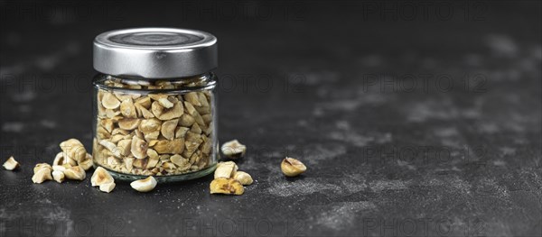 Chopped Hazelnuts on rustic background as close up shot (selective focus)