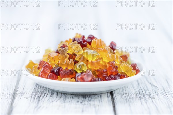 Bowl with Gummy Candy (selective focus) on wooden background