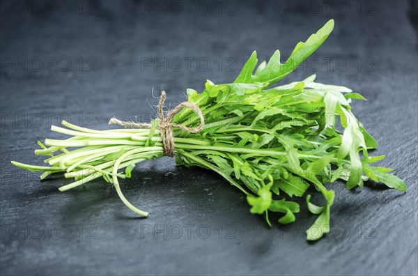 Fresh Arugula (selective focus) as detailed close-up shot on vintage background