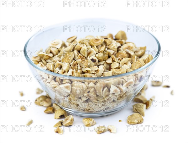 Freshly chopped Hazelnuts as detailed close up shot isolated on white background (selective focus)