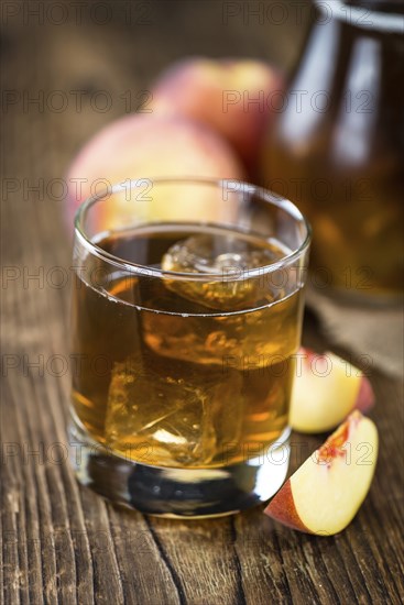 Ice Tea (Peach) on an old wooden table (selective focus, close-up shot)