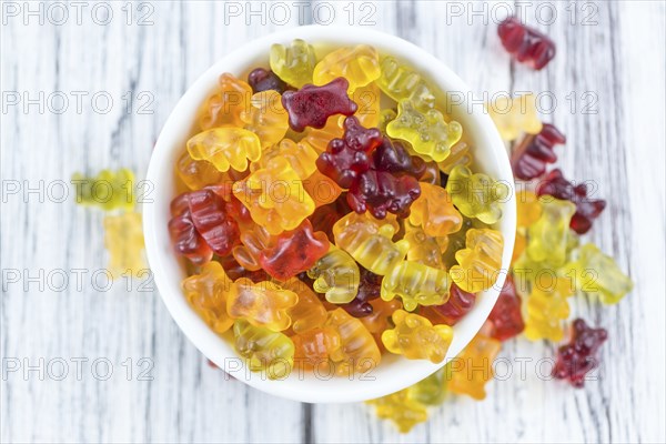 Wooden table with Gummy Bears (close-up shot, selective focus)