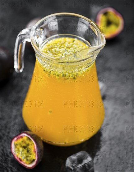 Portion of healthy Maracuja Juice on a slate slab (selective focus)