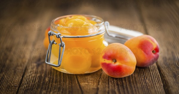 Canned Apricots on an old wooden table as detailed close-up shot (selective focus)