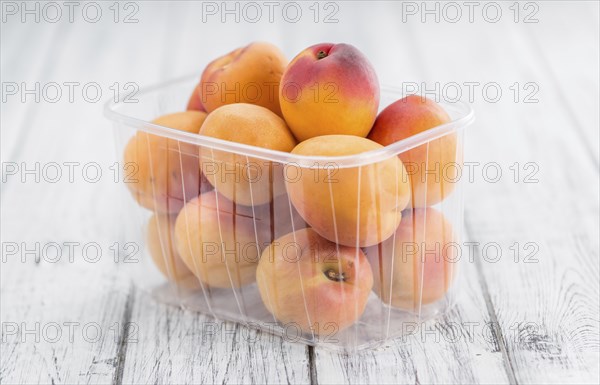 Apricots on an old wooden table as detailed close-up shot (selective focus)
