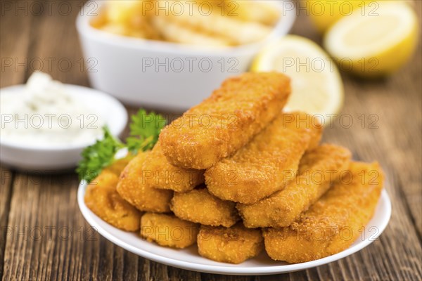 Fisch Sticks (close-up shot) on an old wooden table (selective focus)