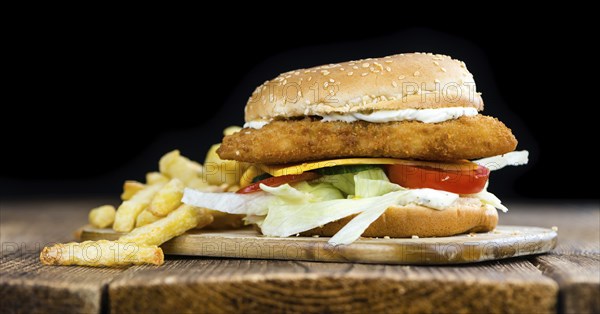 Homemade Fish Burger (close-up shot, selective focus) on a wooden table