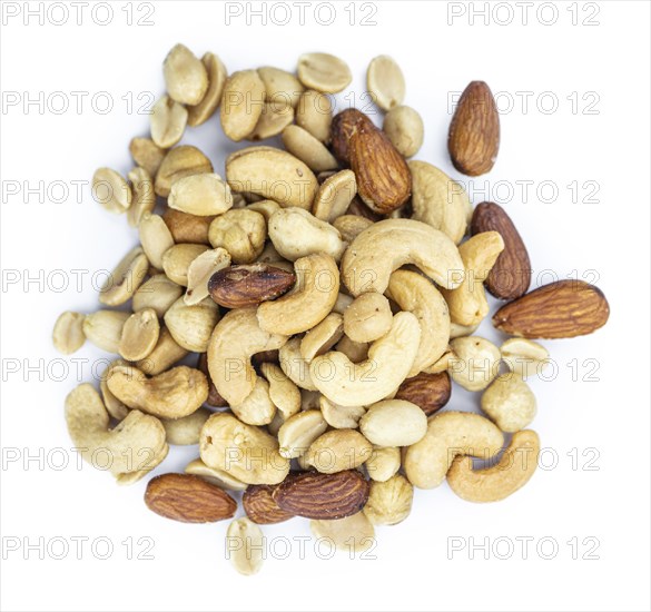 Portion of roasted nuts isolated on white background as close up shot (selective focus)