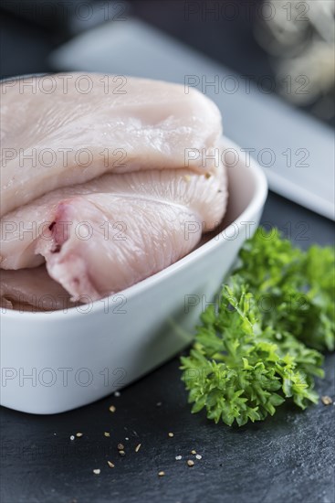 Raw Chicken Cutlet on a slate slab (detailed close-up shot)