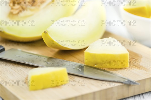 Fresh made Yellow Honeydew Melon on a vintage background (close-up shot)