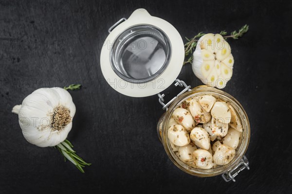 Marinated Garlic on a vintage slate slab (close-up shot, selective focus)