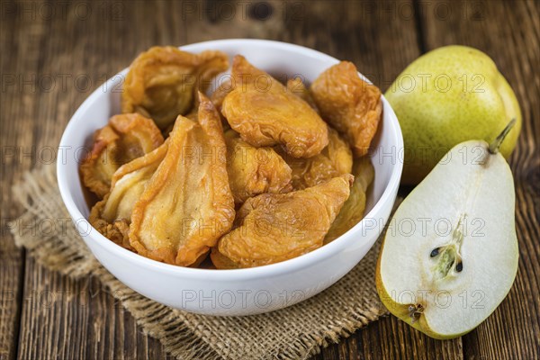 Wooden table with dried Pears (selective focus, close-up shot)