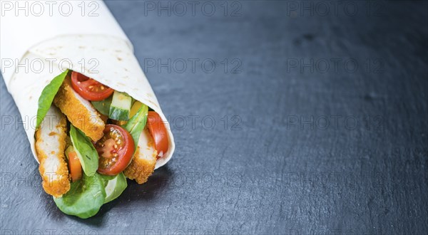 Chicken Wraps (selective focus) on a slate slab (close-up shot)