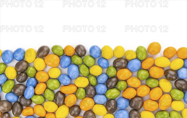 Chocolate coated peanuts isolated on white background (selective focus)