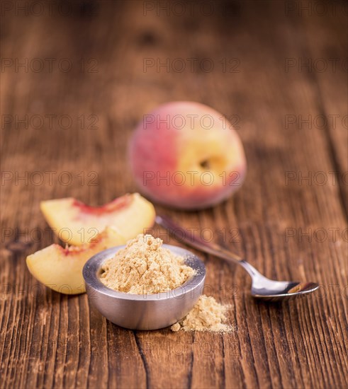 Ground Peaches as high detailed close-up shot on a vintage wooden table, selective focus
