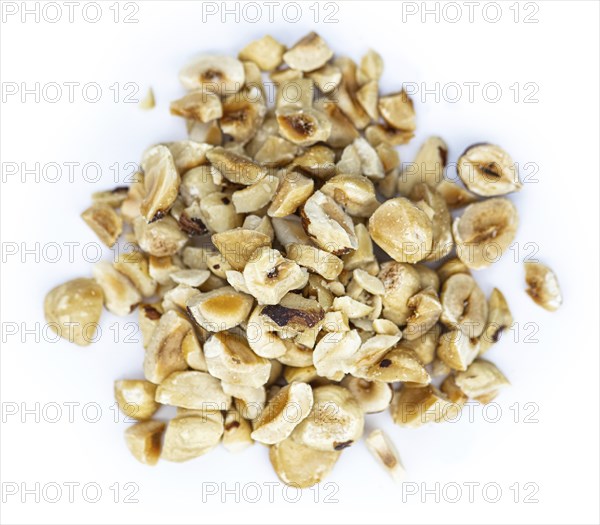 Freshly chopped Hazelnuts as detailed close up shot isolated on white background (selective focus)