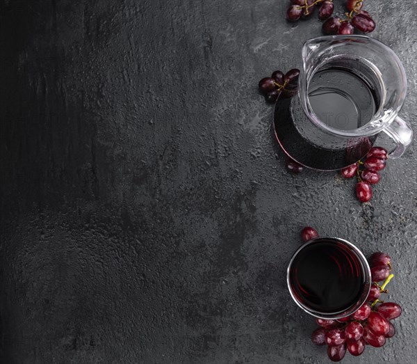 Portion of healthy Red Grape Juice on a slate slab (selective focus)