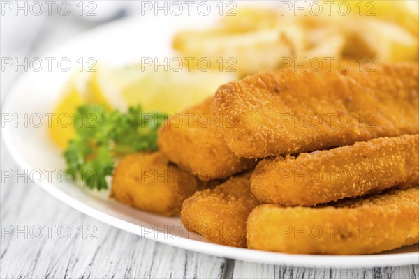 Some fried Fish Sticks (selective focus) on an old wooden table