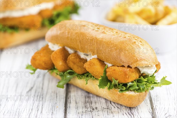 Fresh made Snack (Sandwich with Fish Sticks) on an old wooden table