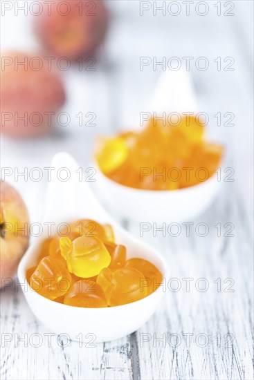 Gummy Peaches (detailed close-up shot) on an old wooden table