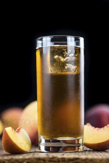 Peach ice tea (selective focus) on an old wooden table (close-up shot)