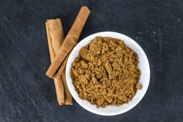 Fresh made Cinnamon Powder on a vintage background (close-up shot)