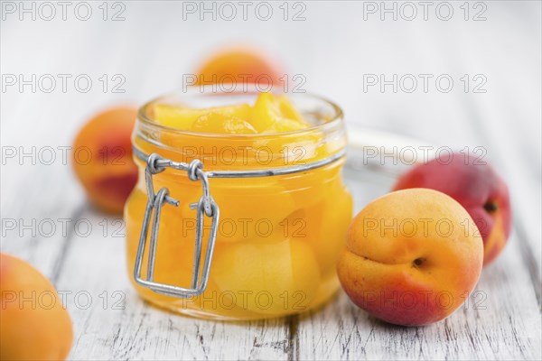 Canned Apricots on an old wooden table as detailed close-up shot (selective focus)