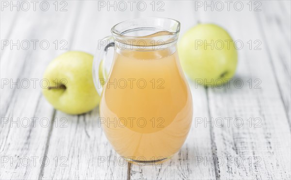 Apple Juice on an old wooden table as detailed close-up shot (selective focus)
