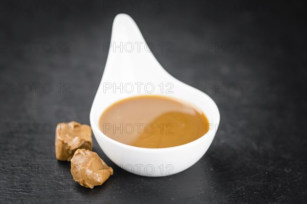 Caramel Sauce on a vintage slate slab (close-up shot, selective focus)