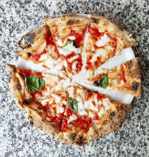 Top view of slices of pizza margherita on marble table